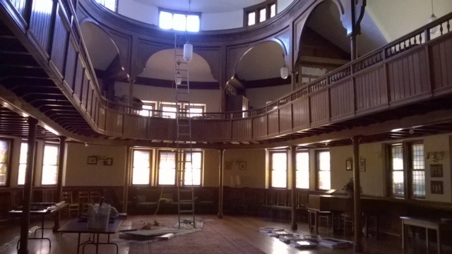 Interior of Harvard Epworth Methodist Church, a wood-paneled hall with a curved balcony on pillars
