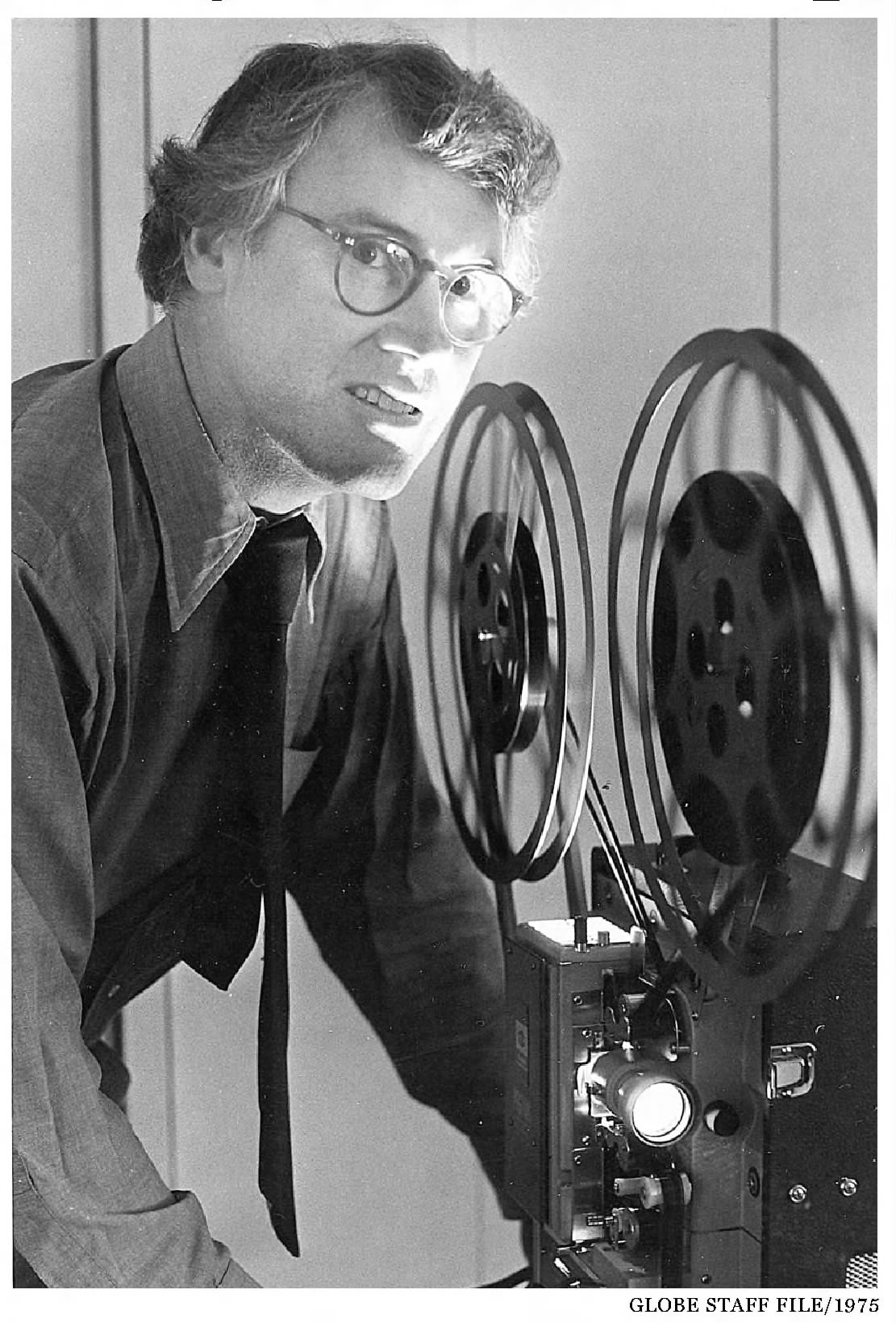Rev. Edward Mark beside a film projector in 1975